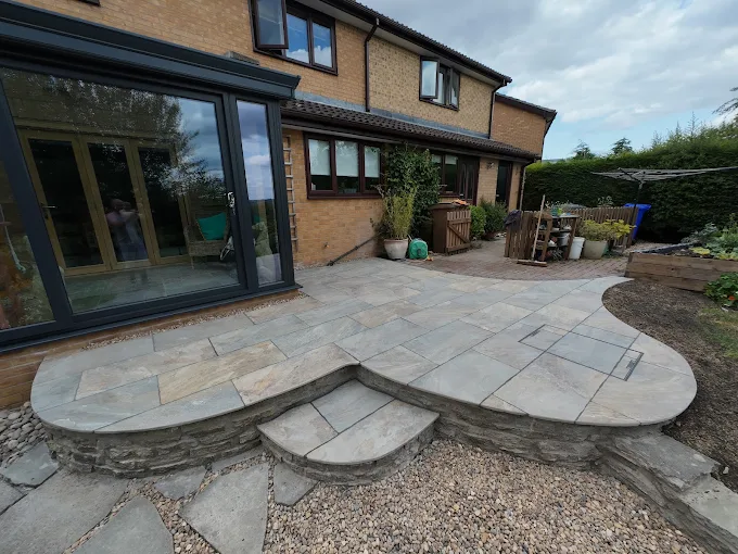Curved stone patio installation by RMS Building and Landscaping